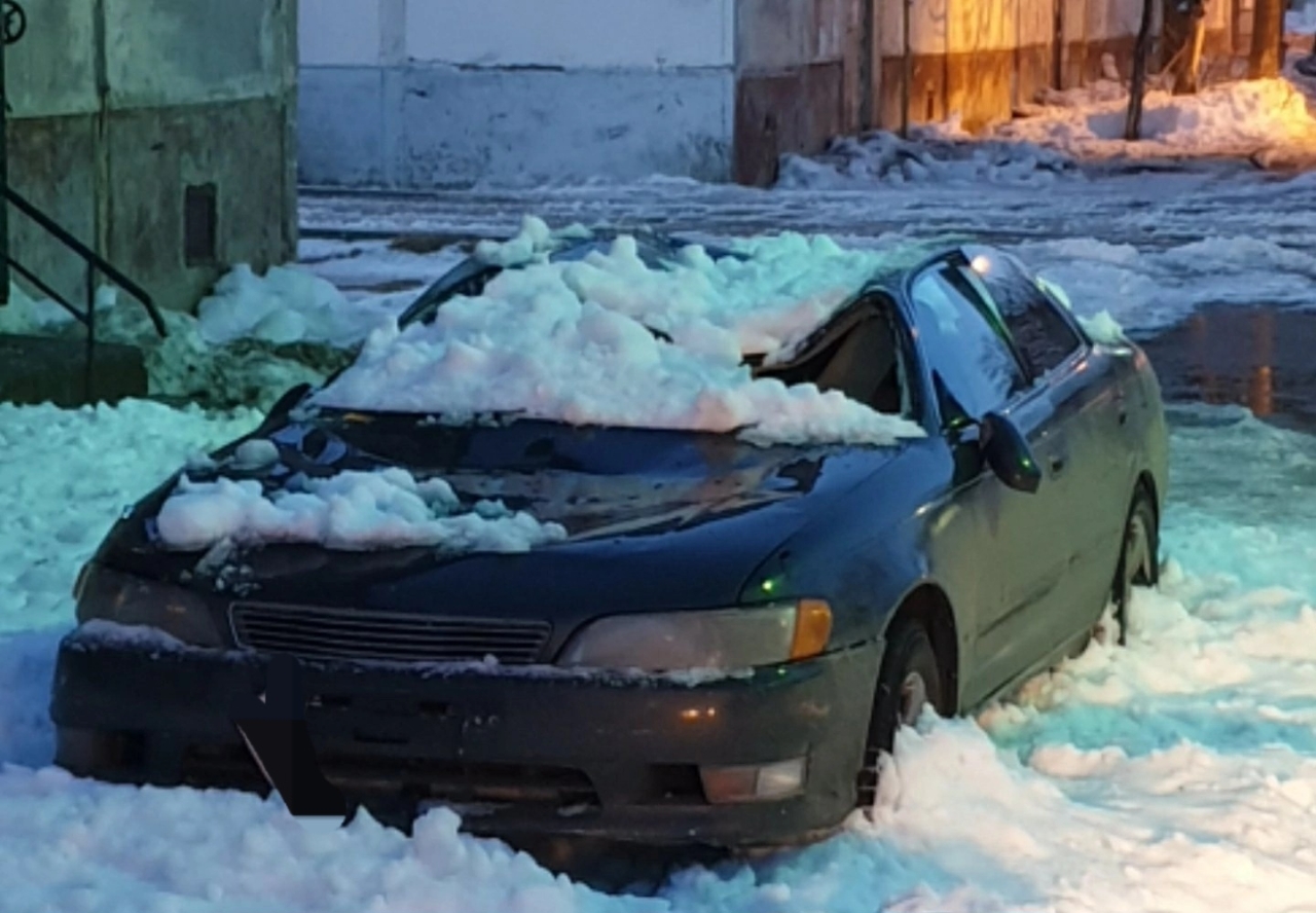 В Охе упавший с крыши снег со льдом повредил припаркованный у дома автомобиль